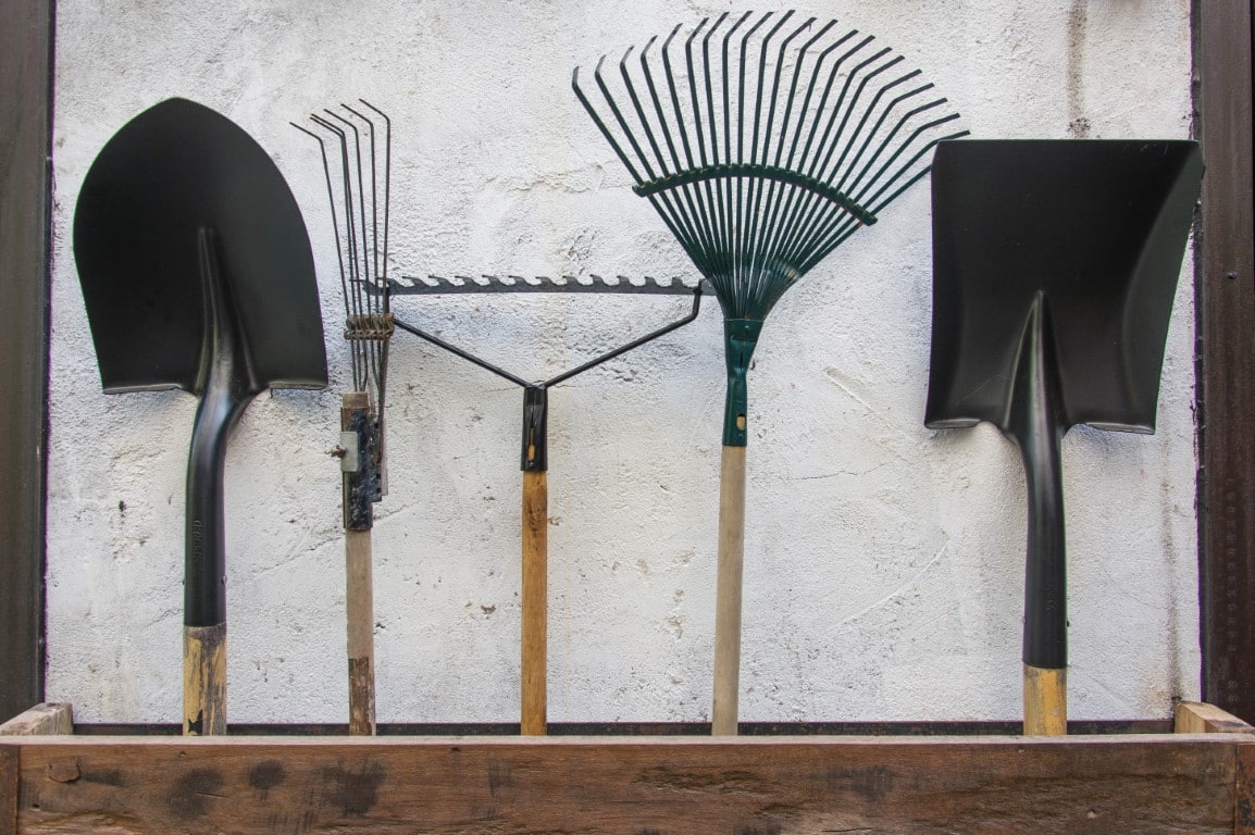 outils à manche disposés contre un mur